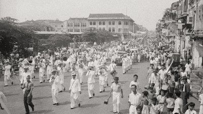 A brass band leads a procession of the people of Singapore in a celebratory parade to mark the end of Japanese rule.