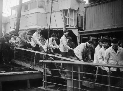 Scharnhorst Survivors at Scapa Flow, 2 January 1944 Blindfolded SCHARNHORST survivors, in merchant seaman rescue kit, walking down a gang-plank on their way to internment.